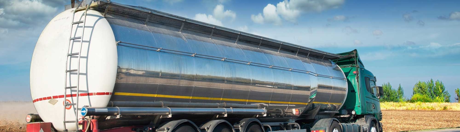 Tank truck driving down the road on a sunny day