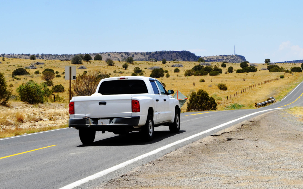 View of a white pickup driving down the road