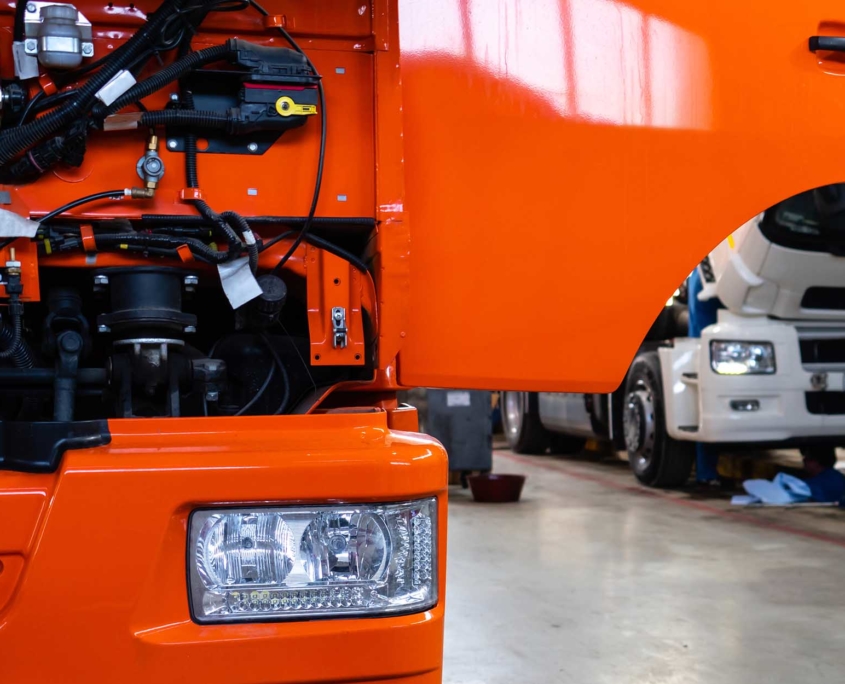 Close up view of an orange truck with the hood open