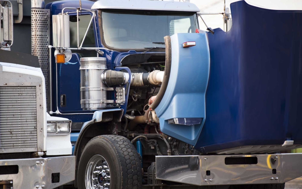 Side view of a blue truck with the hood open