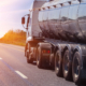 Tank truck driving down the road at sunset