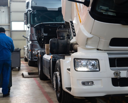 Two semitrucks being serviced at a repair shop