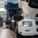 Two semitrucks being serviced at a repair shop