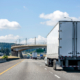 Big rig white semi truck transporting cargo in dry van semi trailer