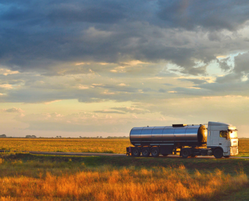 Truck driving on a road at sunset