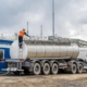 Worker on back ladder of their tank truck